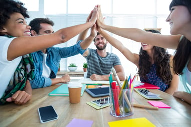 Creative business team putting hands together at the office